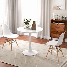 two white chairs and a table in a room