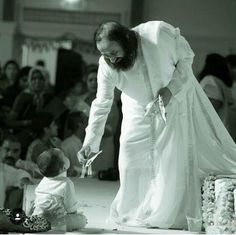 a black and white photo of a man with a baby in front of him at a wedding