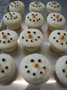 cupcakes with frosting and black dots are arranged in the shape of snowmen