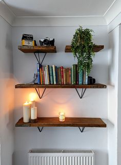 two shelves with books and candles on them