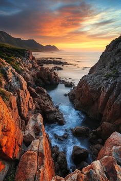 the sun is setting over some rocks and water