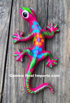 a brightly colored lizard sitting on top of a wooden floor