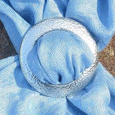 a silver ring sitting on top of a blue cloth