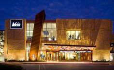 an illuminated building with people standing outside at night