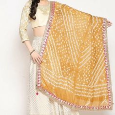 Silk Dimensions Width: 44 Metres; Length: 2.5 Inches Description Handmade Item WELCOME TO TieDyeDupatta Color :- Golden Size:- Length : 2.5 Meters Width : 44 Inches Material: Thread, Silk  ETHNICITY CHUNRI SCARVES DUPATTA  1 PCS SOLID COLOR Dupatta, Rajasthani Bandhej Dupatta tapara Silk Bandhani Bandhej Gota Patti Bail With Moti Border Women Heavy Dupatta Beautiful silk Indian dupatta with a hand dyed traditional chunri design. This solid tie-and-dye scarf has a very soft and light weight fabri Beige Dupatta For Navratri, Beige Dupatta For Diwali, Beige Cutdana Dupatta For Navratri, Bohemian Bandhani Print Choli For Wedding, Bohemian Wedding Choli With Bandhani Print, Gold Choli With Gota Work, Beige Traditional Wear With Gota Work For Festivals, Yellow Gota Work Dupatta For Puja, Bohemian Yellow Lehenga For Festivals