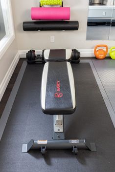 a gym room with exercise equipment and yoga mats