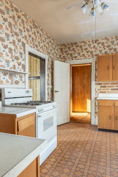 an empty kitchen with wooden cabinets and white appliances