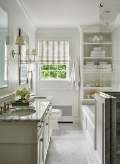 a bathroom with white walls and marble counter tops