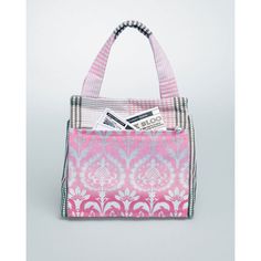 a pink and white handbag sitting on top of a table