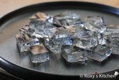 some ice cubes sitting on top of a black plate