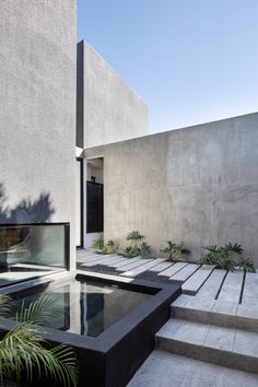 an outdoor area with water and plants on the outside, along with steps leading up to it