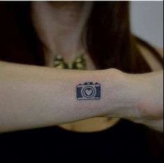 a woman with a camera tattoo on her arm