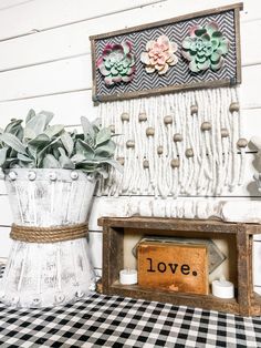 two vases with succulents are sitting on a checkered tablecloth