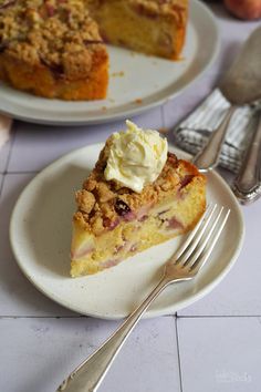 a piece of pie on a plate with a fork next to it and another cake in the background