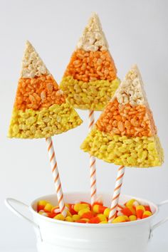 three candy trees in a white bowl with candy sticks sticking out of it's top