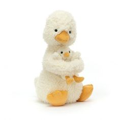 a stuffed duck with its baby sitting next to it's mother on a white background