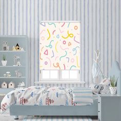 a child's bedroom with blue and white striped wallpaper, colorful window blinds and bed in the foreground