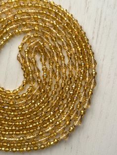 -Listing is for one 50 inch tie-on luxury waist bead -Created on traditional Ghanian string -High-quality gold 6/0 seed beads -Genuine gold faceted rondelle  and bicone crystal beads -Colors: gold, gold, and gold  Benefits of waist beads:  Monitor weight loss/gain: as you lose weight your weight, your waist beads will fall down towards your hips; as you gain weight your waist beads will get tighter and rise up your waist Increase sensuality: very enticing in the bedroom; men love to see them move 😊 Improve body awareness: beads around your waist remind you to stand tall and engage your abdomen as you walk Promote self-love: waist beads cover your blemishes and stretch marks and make your tummy even more beautiful; Spiritual practice: you can cleanse and bless your waist beads before you t Gold Waist Beads, Body Beads, Beads Colors, Gold Crystals, Body Awareness, Waist Beads, Belly Chain, Gain Weight, Crystal Collection