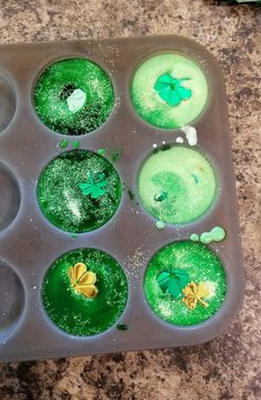 cupcakes with green icing in a muffin pan on a counter top