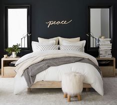 a bedroom with black walls and white bedding