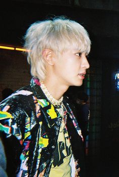 a man with blonde hair wearing a colorful jacket