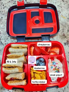 an open red lunch box with sandwiches, fruit and yogurt