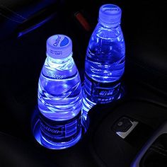 two bottled water bottles sitting on top of a car dashboard next to a charger