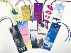 six bookmarks with the names of different authors on them, hanging from strings and decorated with string