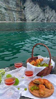 some food and drinks on a table by the water