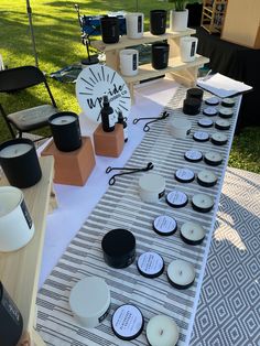 the table is set up with candles and other items for sale at an outdoor event