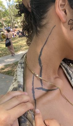 a woman with tattoos on her neck is getting ready to put something in her ear