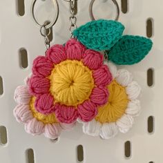 a crocheted flower keychain hanging from a hook