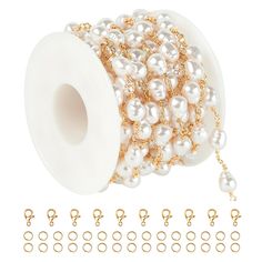 a spool of white pearls and gold chains on a white background with other beads