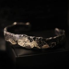 If you're the type of person to wear chunky jewelry, you came to the right place. This heavy piece of sterling silver weighs 63 grams and works well as a set with the Ring of the Elders. The Cuff of the Elders combines rough surfaces with polished areas. The inside of the band has 'Book of Alchemy' engraved in it. The width of the band is 1.5cm, the inside diameter of the piece is 6.9cm. Shipping&Processing Since all our items are individually handmade, we need about 4 weeks (at most) to make yo Silver Hand Cast Metal Cuff Bracelet, Silver Metal Cuff Bracelet Hand Cast, Unique Silver Hammered Jewelry, Unique Hammered Silver Jewelry, Brutalist Sterling Silver Jewelry With Hammered Detail, Hand Forged Silver Brutalist Jewelry, Engraved Sterling Silver Brutalist Jewelry, Brutalist Hammered Sterling Silver Jewelry, Artisan Metal Jewelry With Polished Finish