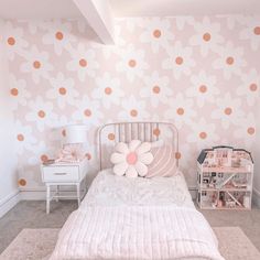 a white bed sitting next to a pink wall with orange polka dotes on it