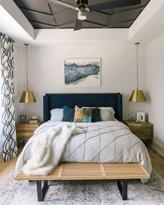 a bedroom with a bed, nightstands and paintings on the wall