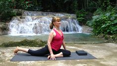 a woman is doing yoga in front of a waterfall