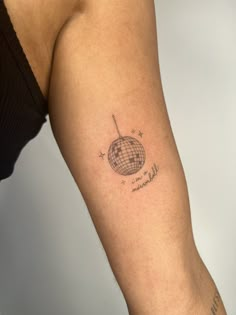 a woman's arm with a small globe tattoo on the left side of her arm