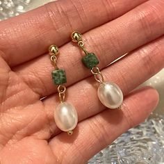 Looking for the perfect accessory to add a pop of color to your outfit? Look no further than these stunning handmade faux pearl green drop earrings! Each earring features a gorgeous green faux pearl, carefully crafted to mimic the look of real pearls. The drop style of the earrings adds an elegant touch, making them perfect for both casual and formal occasions. These earrings are not only beautiful, but also eco-friendly, as they are made from sustainable materials. Plus, they're handmade with care, ensuring that each pair is unique and of the highest quality. Treat yourself or a loved one to these beautiful earrings today! 💎 Features: ♥ Handmade ♥ Material: 14K Gold plated silver ♥ Main stone: faux pearl ♥ Screw back Closure 💎 Details: ♥ Approximate Measurements: - Length: 2.8 cm - Widt Trendy Pearl Charm Drop Earrings, Trendy Dangle Pearl Drop Earrings, Trendy Pearl Drop Dangle Earrings, Green Pearl Charm Drop Earrings, Green Dangle Pearl Earrings, Green Pearl Dangle Earrings, Elegant Green Pearl Earrings Gift, Green Baroque Pearl Jewelry For Gift, Green Dangle Pearl Earrings For Pierced Ears