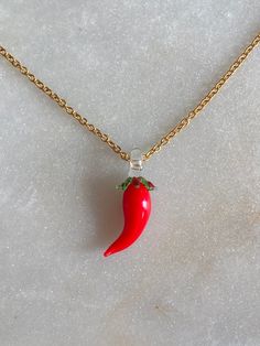 Red Hot Chilli Pepper glass charm with 14k gold plated chain. Not including the loop, the pendant is about 2.5 cm (1 inch) long and 1 cm (0.4 inches) wide. All the pendants and charms are created by melting borosilicate glass rods using a torch and annealed in a digitally controlled kiln for long-lasting durability. Due to the unique nature of this jewelry, each necklace will be slightly different. Nickel Free Glass Pendant Jewelry, Red Charms Round Pendant Necklace, Red Charms Necklace With Round Pendant, Yellow Gold Necklaces With Glass For Gift, Red Necklace With Round Pendant And Charms, Red Necklace With Charms And Round Pendant, Yellow Gold Glass Necklaces As Gift, Yellow Gold Glass Necklace As Gift, Glass Pendant Necklaces For Gifts