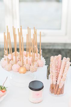 there are many desserts on the table with gold sticks and strawberries in them