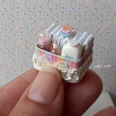 someone is holding a miniature toothbrush holder with baby items in it's mouth