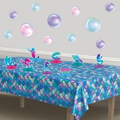 the table is covered with blue and pink mermaid themed decorations