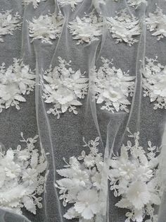 wedding veils with white flowers and ribbons on the bottom are lined up in rows