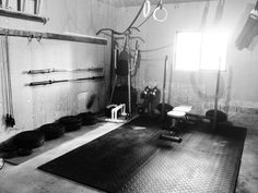 a gym room with several different equipment in the corner and one on the floor next to it