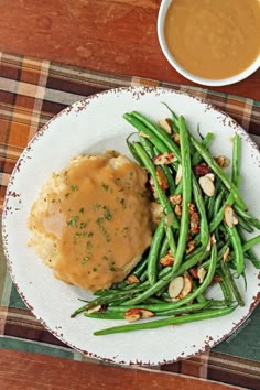 a white plate topped with green beans and gravy