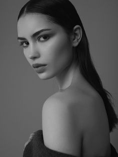 a black and white photo of a woman with her hair in a pony tail ponytail