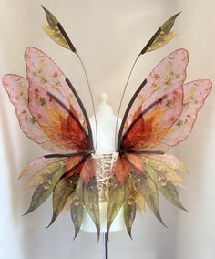 a white mannequin headdress with an orange and red butterfly on it