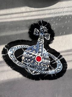 a black and silver brooch sitting on top of a table