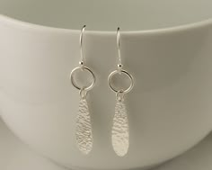 These sterling silver earrings were inspired by the simple curved line of a water droplet. They are handmade from solid sterling silver. I hammered and tumbled them for strength and then polished them for a shiny finish. This hammered texture glistens beautifully in the light. The earrings measure approximately 2 inches in length including the sterling silver ear-wires. Currently in Stock & ready to ship Domestic Shipping includes Delivery Confirmation with tracking Matching Necklace availab Hammered Metal Jewelry, Simple Silver Earrings, Hammered Silver Jewelry, Lariat Necklace Silver, Metal Jewelry Making, Handmade Silver Jewellery, Dangle Earrings Silver, Metal Clay Jewelry, Earrings Handmade Dangle